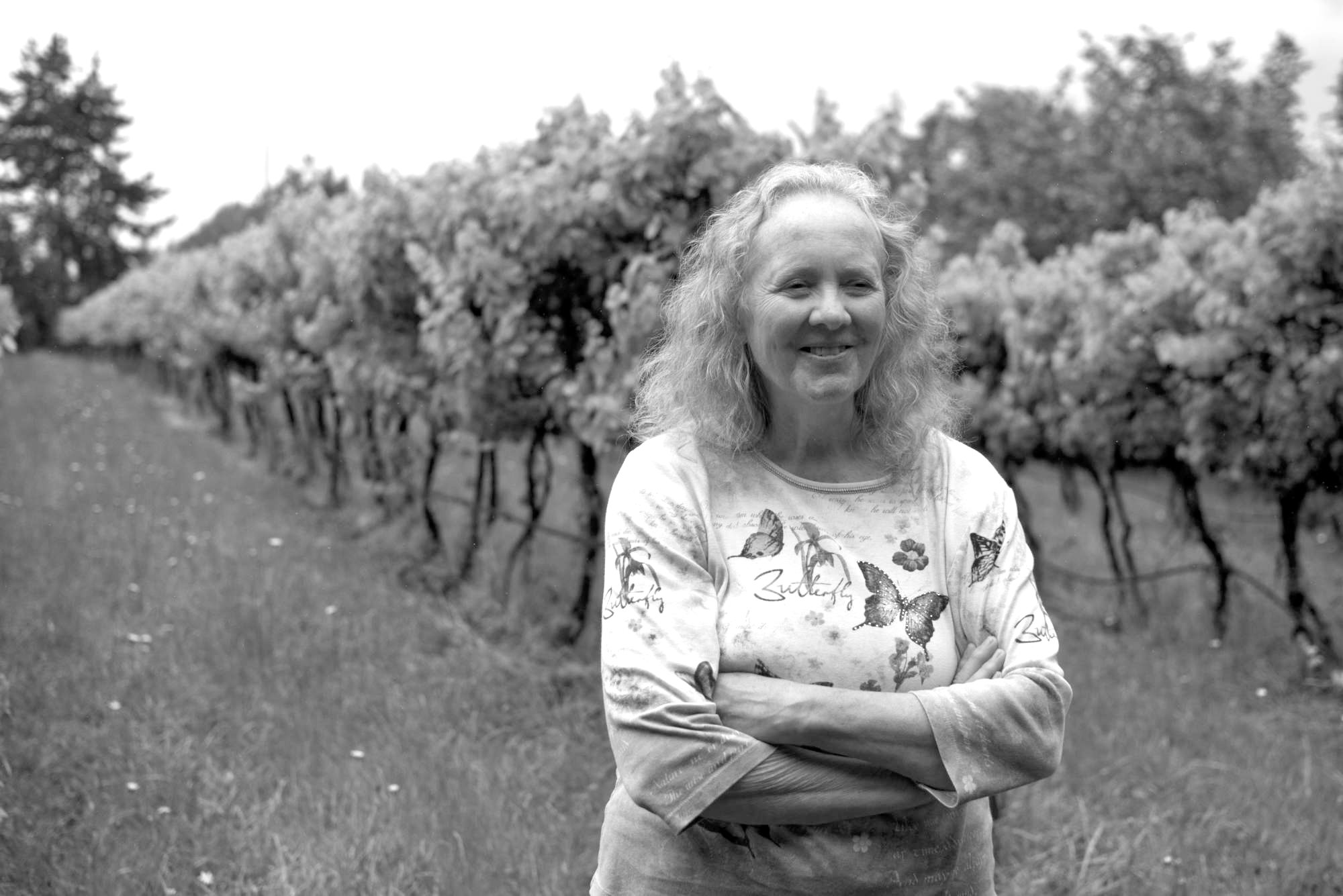 Jan Wallinder stands in front of grape vines at Forest Edge Vineyard